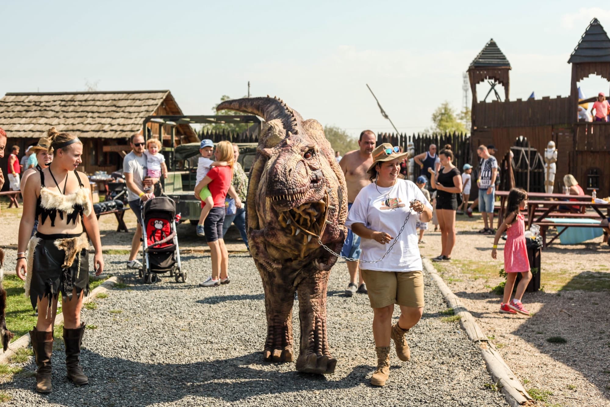 Dinosaurus se prochází mezi návštěvníky akce a zastavuje se u dětí