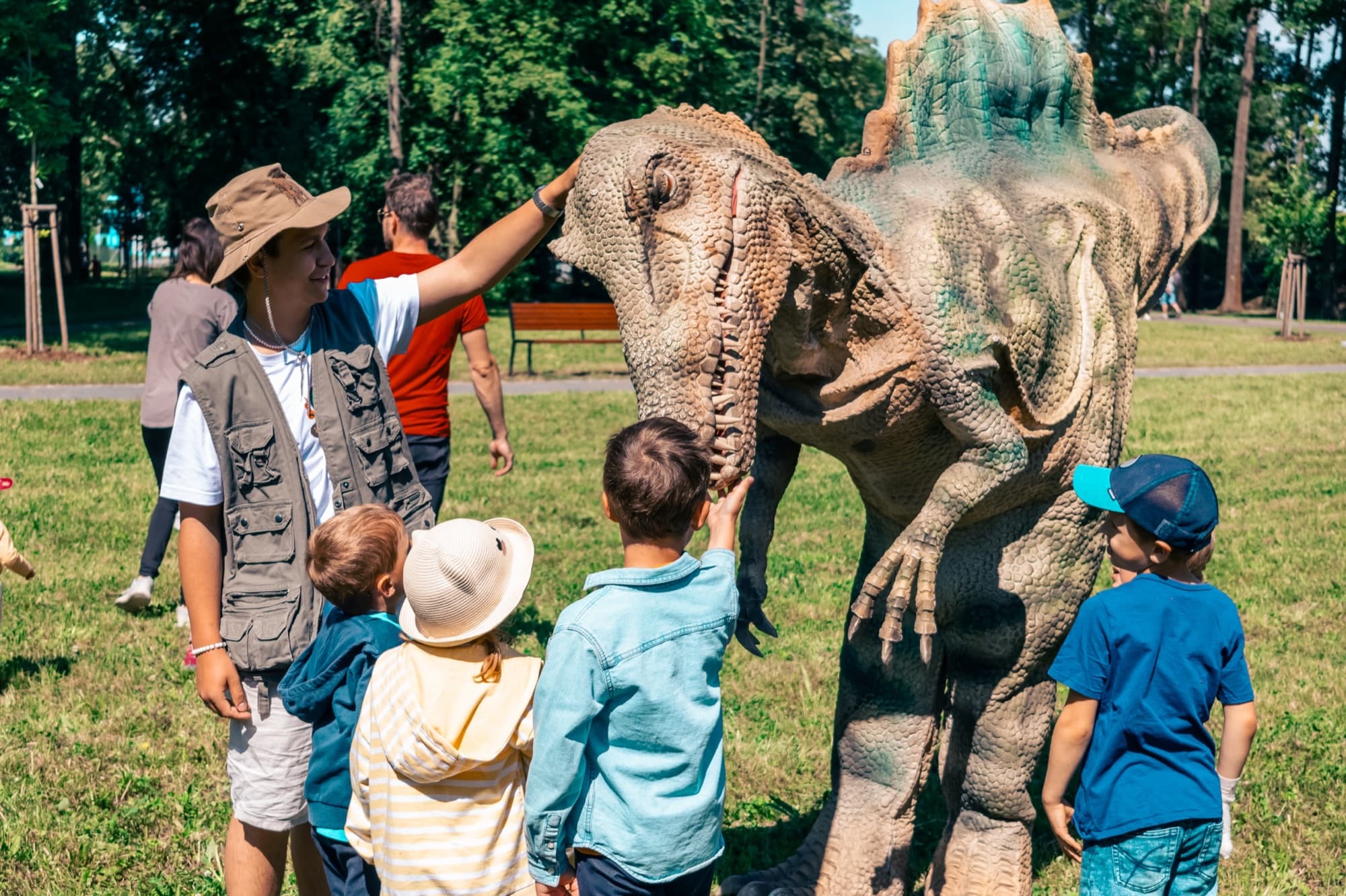 Animátor v roli paleontologa ukazuje dětem dinosaura zblízka
