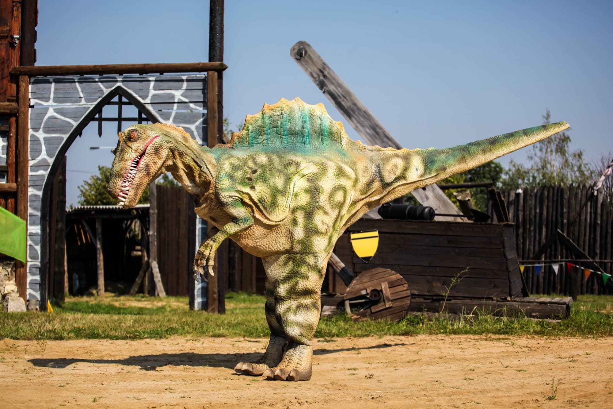 Spinosaurus v celém kostýmu stojí na place před začátkem programu